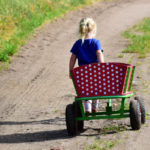 child walking down road pulling wagon to symbolize relocating in custody action
