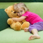 child hugging teddy bear to symbolize child custody