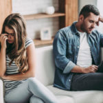 couple sitting on opposite ends of a couch symbolizing reasons for divorce